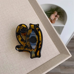 Detailed view of an acrylic devil eye hair claw with brown tortoiseshell texture