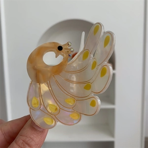 Detail of peacock hair claw clip with colorful resin marble texture and rhinestone accents