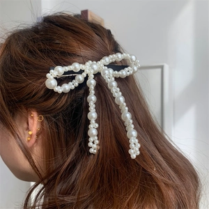Dettaglio di un fermaglio per capelli in perle fatto a mano a forma di fiocco