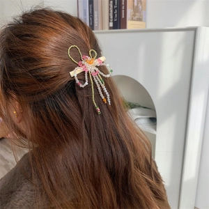 Barrette à cheveux faite main avec perles et nœud à glands sur cheveux bruns