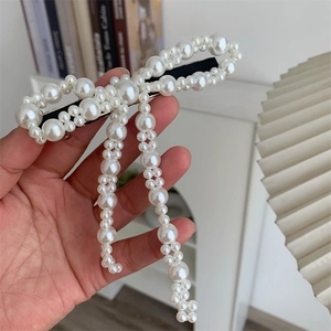 Dettaglio di un grande fermaglio per capelli a fiocco di perle fatte a mano con base