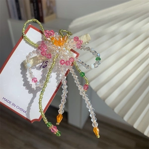Détail de la pince à cheveux fleurie faite main avec perles en cristal rose et tissu