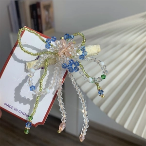Vue détaillée d'une pince à cheveux fleurie faite main avec des perles de cristal