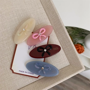 Close-up of acetic acid hair clips with bows and rhinestones in four soft colors