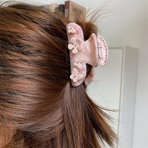 Detailaufnahme der rosa marmorierten Haarklammer aus Acetat mit Blumen und Schmetterlingen