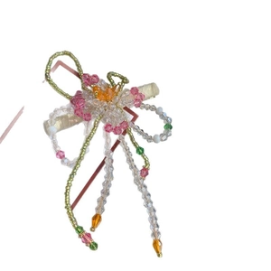 Pince à cheveux fleurie en perles avec cristaux roses et élégante frange à pompons