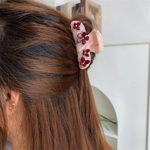 Nahaufnahme einer floralen Haarklammer aus Acetat im Haar mit feinen Details und Glanz