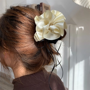 Chouchou en satin crème élégant avec un ruban noir en soie sur les cheveux