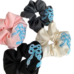 Set of four satin scrunchies with blue snake embroidery in pink black grey and beige colors