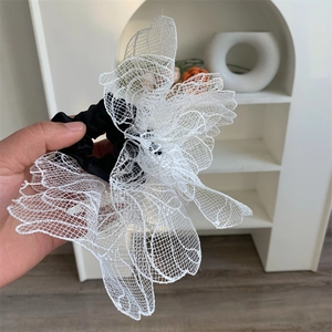 Macro shot of large white lace mesh scrunchie with layered ruffles and elastic band