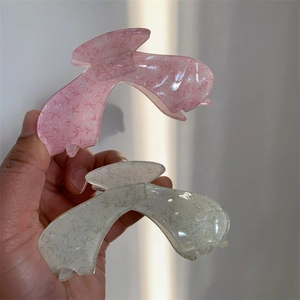 Close-up of translucent acrylic hair clips with fine floral patterns and glitter details