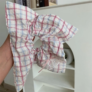 Détail d'un chouchou à carreaux rose et bleu avec dentelle blanche et petit nœud