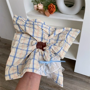 Gros plan d'un chouchou à carreaux avec bordure en dentelle et nœud en ruban bleu
