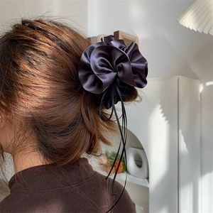 Vue détaillée du chouchou fleur en satin gris foncé avec de longs rubans fins