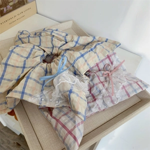 Détail de chouchous à carreaux avec dentelle blanche et petits nœuds sur un plateau