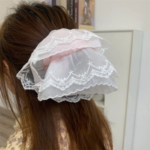Close-up detail of oversized double-layer lace hair scrunchie with pink satin inner