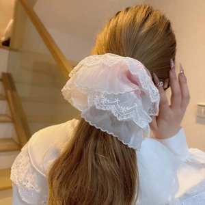 Detailed close-up of large double-layered lace scrunchie with floral embroidery pattern
