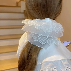 Close-up of a white oversized double-layer lace scrunchie on a woman's hair