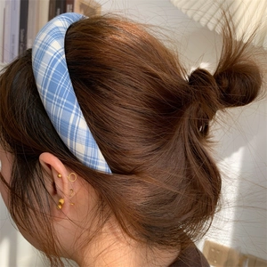 Detail shot of a blue and white checkered sponge headband on model with soft lighting