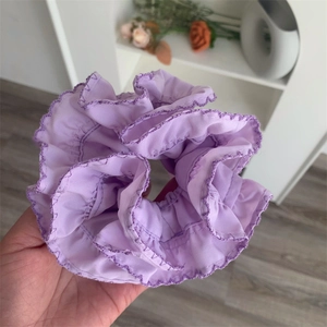 Detail of purple chiffon scrunchie showing delicate wavy stitched edges and soft pleats