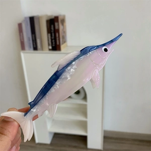 Détail de la pince à cheveux espadon en acétate marbré rose et bleu avec nageoire sculptée