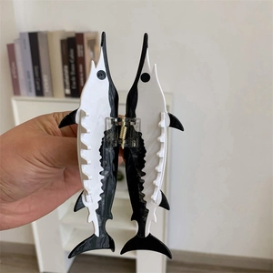 Détail de la pince à cheveux en forme d'espadon en acétate aux tons noir et blanc