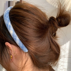 Classic blue and white plaid fabric headband worn by a model with a natural hair look