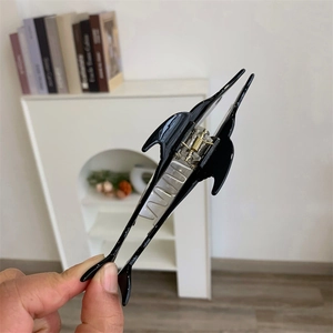 Détail d'une pince à cheveux dauphin noire élégante en résine d'acétate polie