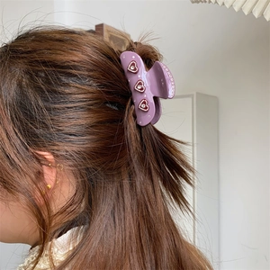 Eleganter violetter Haar-Greifclip aus Harz mit roten Herz-Strasssteinen am Model