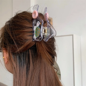 Detail of tortoise shell acetate hair claw clip worn on hair with cute turtle pattern