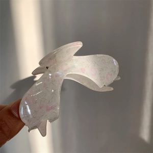 Detail of floral acrylic hair claw clip with pink flowers and silver glitter finish