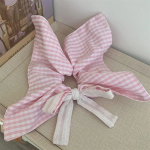 Detail of pink plaid cotton hair scrunchie with large bow and white lace trim detail