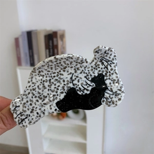 Détail d'une pince à cheveux en acétate faite main avec motif chat noir et texture tachetée