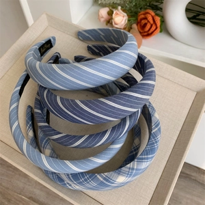 Close-up of blue plaid and striped fabric headbands with sponge padding on a tray