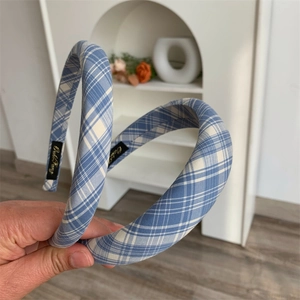 Detail of blue and white plaid fabric headband with thick padding and inner brand label