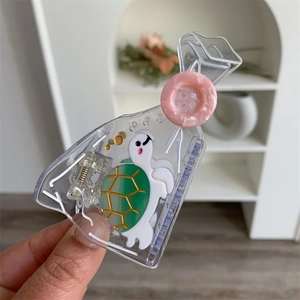 Close-up of a creative clear turtle hair claw with unique candy bag shaped design