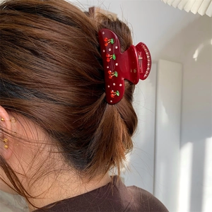 Eleganter Haarkrebs mit Kirschmotiv und Strasssteinen in einer Hochsteckfrisur getragen