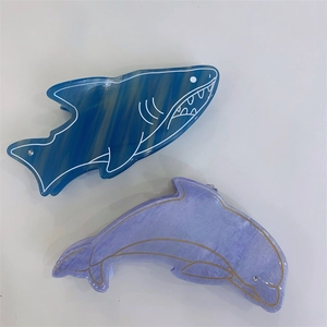 Vue détaillée de pinces à cheveux en acétate en forme de requin et dauphin marbrés