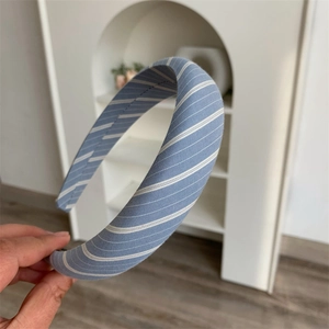 Detailed close-up of light blue and white striped padded headband with soft cotton texture