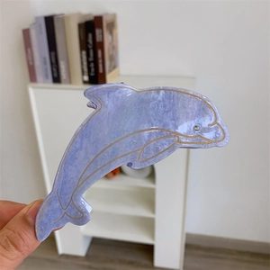 Détail d'une pince à cheveux dauphin en acétate marbré violet avec lignes dorées