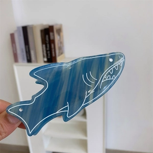 Détail de la pince à cheveux requin en acétate marbré bleu avec des strass étincelants