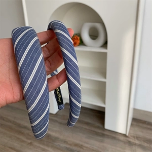 Detailed close-up showing blue and white striped fabric texture on wide padded headbands
