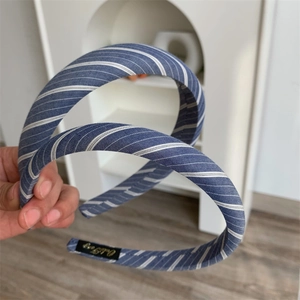 Detailed shot showing the padded blue and white striped fabric headband with branding label