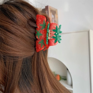 Detail of strawberry shaped hair claw clip made of red acetate on hair