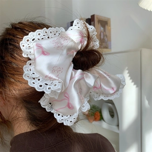 Detailed view of oversized satin scrunchie with lace edge and cute puppy print