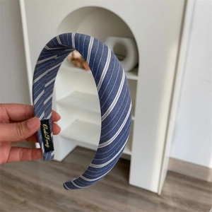 Detail of a blue and white striped fabric headband with a wide-brimmed padded design