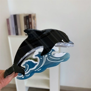 Détail d'une pince à cheveux dauphin et vague de l'océan fabriquée en acétate