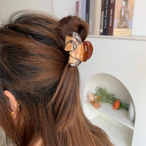 Detailed view of an amber marble acetate hair claw clip styled in a half-up hairdo