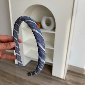 Detailed close-up of a blue and white checkered fabric headband with soft sponge texture