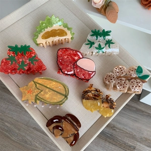Macro shot of assorted fruit and nut acetate hair claws arranged on a display tray